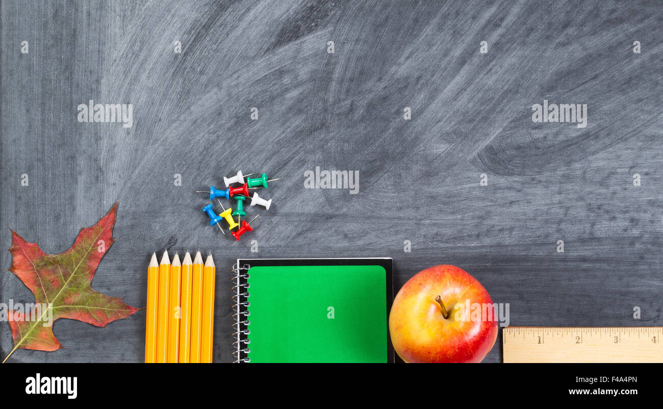 Les fournitures scolaires plus feuille d'automne sur le tableau. Concept Retour à l'école pour l'automne saison avec beaucoup d'espace de copie. Banque D'Images