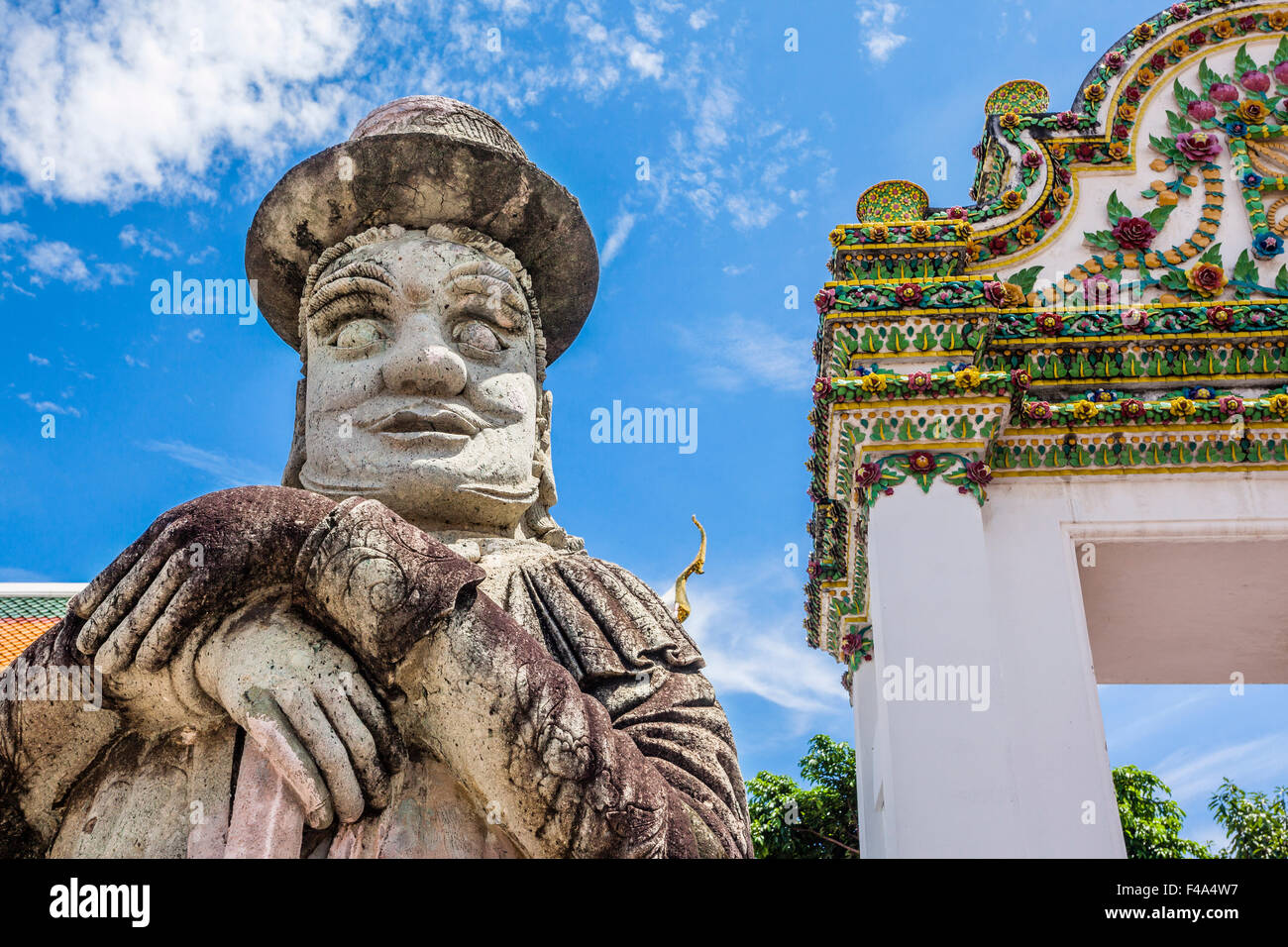 Thaïlande, Bangkok, Wat Po, warrier statue avec top hat garde la porte du temple bouddhiste Banque D'Images