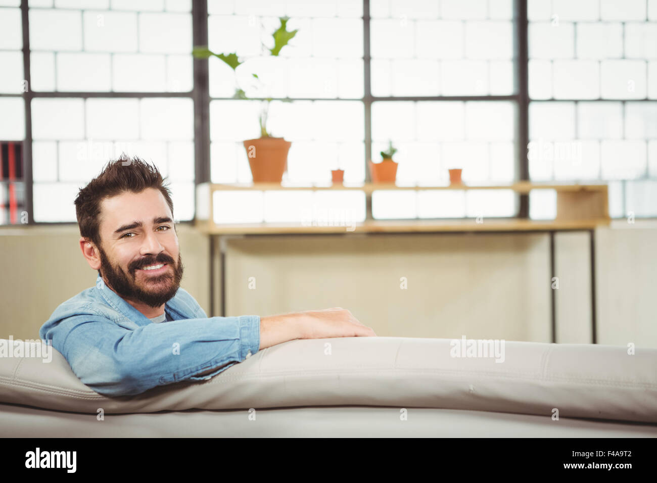 Portrait of happy man sitting on sofa Banque D'Images