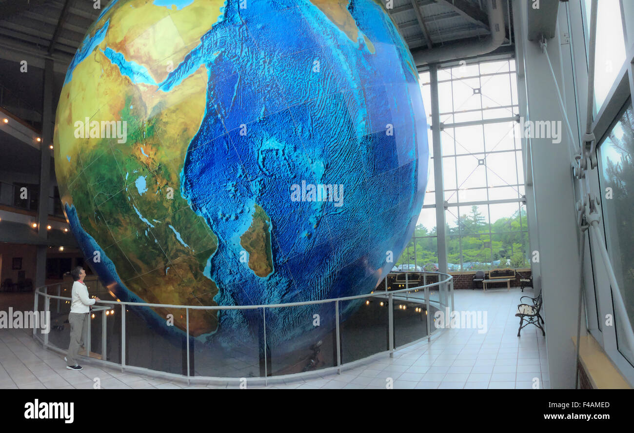 Femme regardant Delorme globe globe en rotation plus importante d'Eartha nommé en Amérique du Nord à l'administration centrale à Yarmouth Maine Banque D'Images