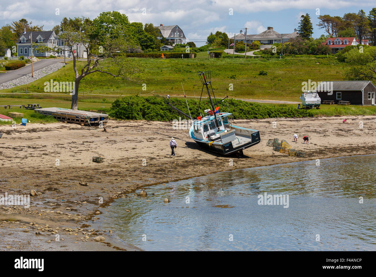 Homme seul sur la plage près de bateau de pêche échoués dans le maquereau Cove Maine USA Banque D'Images