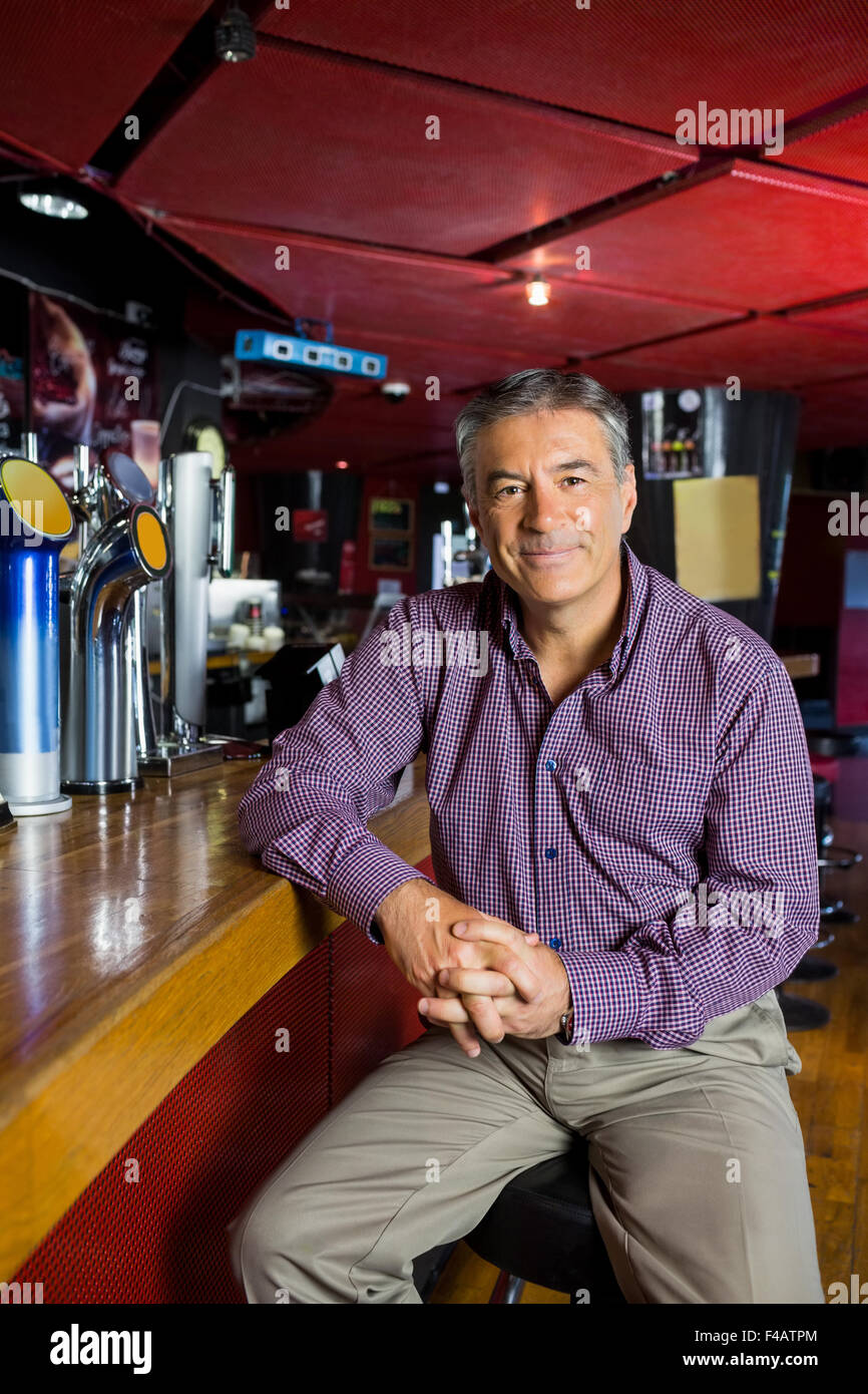 L'homme aux cheveux gris assis au comptoir Banque D'Images