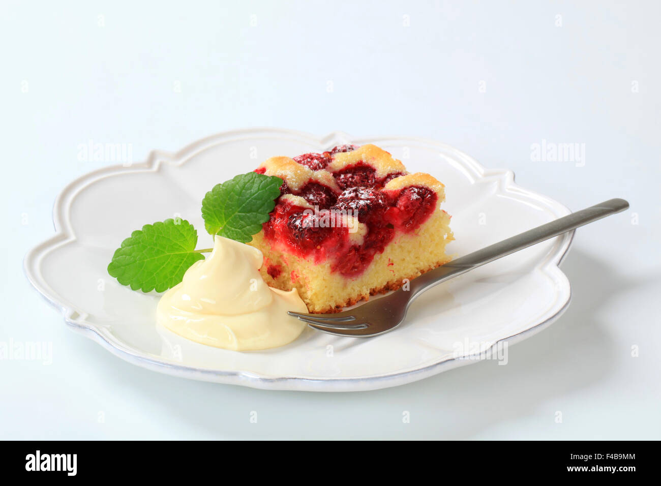 Gâteau framboises coupe avec crème vanille Banque D'Images