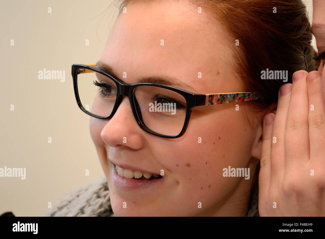 Personne chuchote dans l'oreille d'un adolescent Banque D'Images