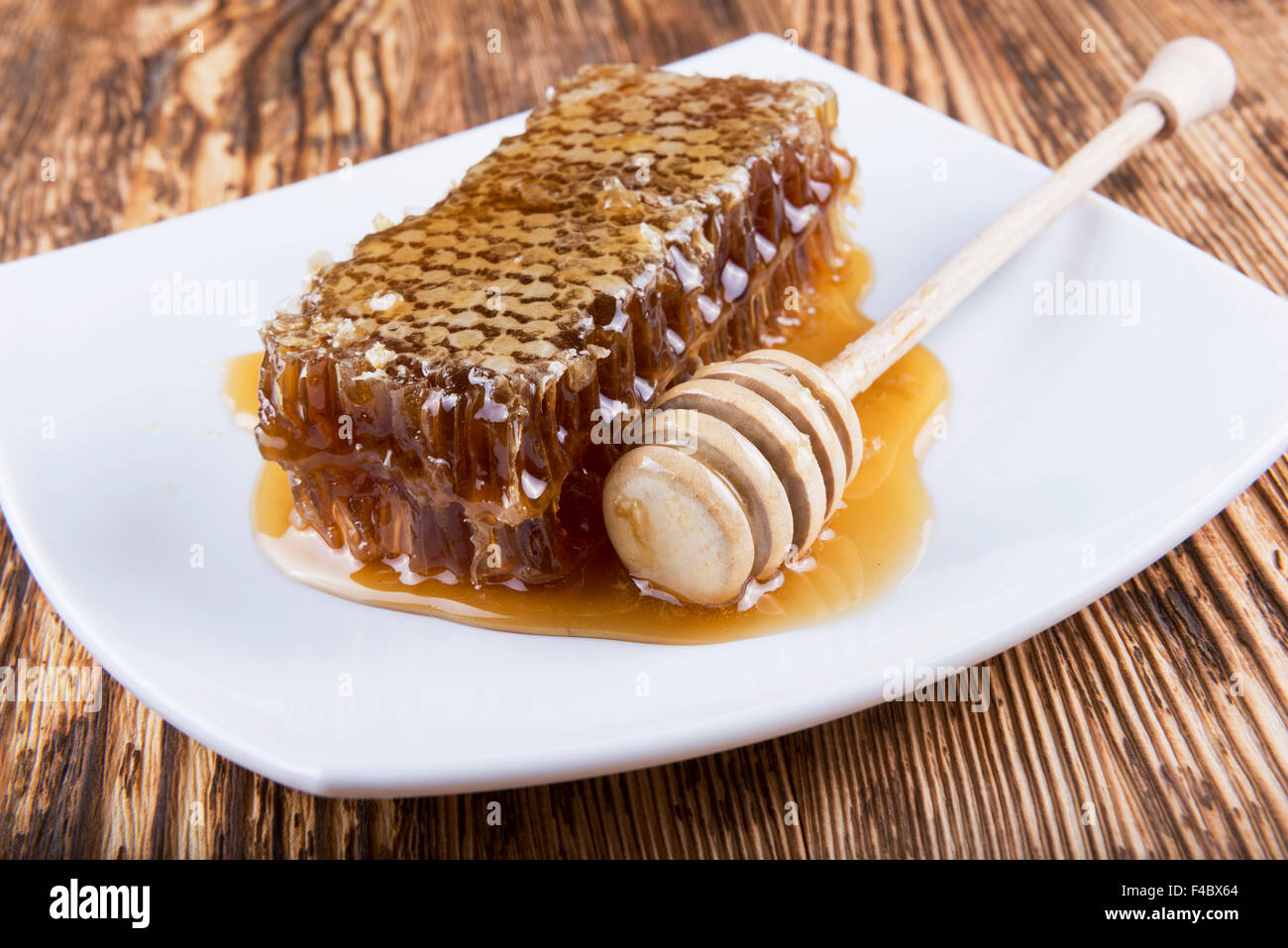 Miel et bâton à miel sur fond de bois Banque D'Images