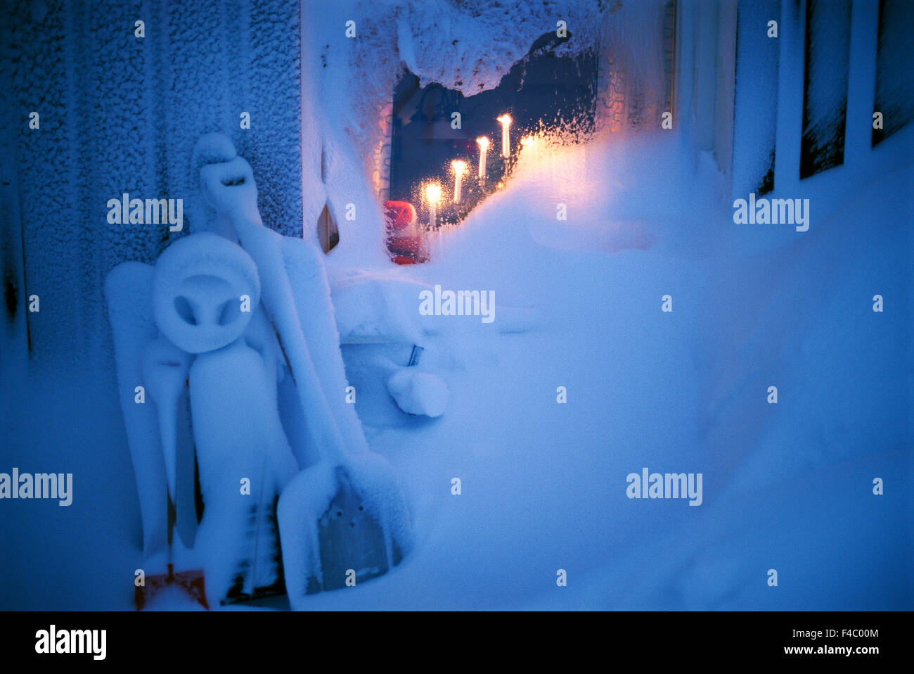 Façade de maison couverte de neige avec avènement chandelier dans la fenêtre. Banque D'Images
