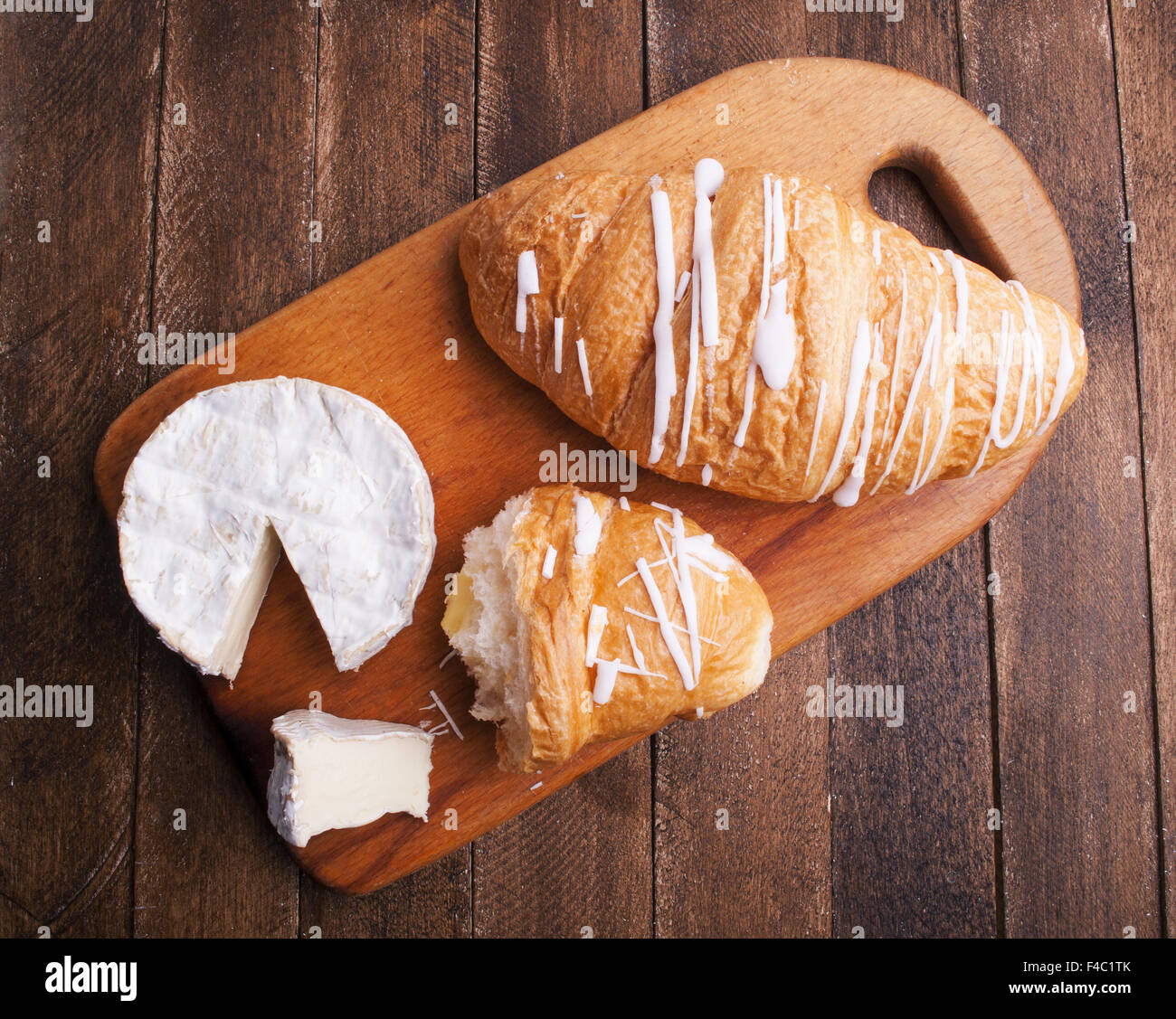 Croissant et fromage sur planche de bois Banque D'Images