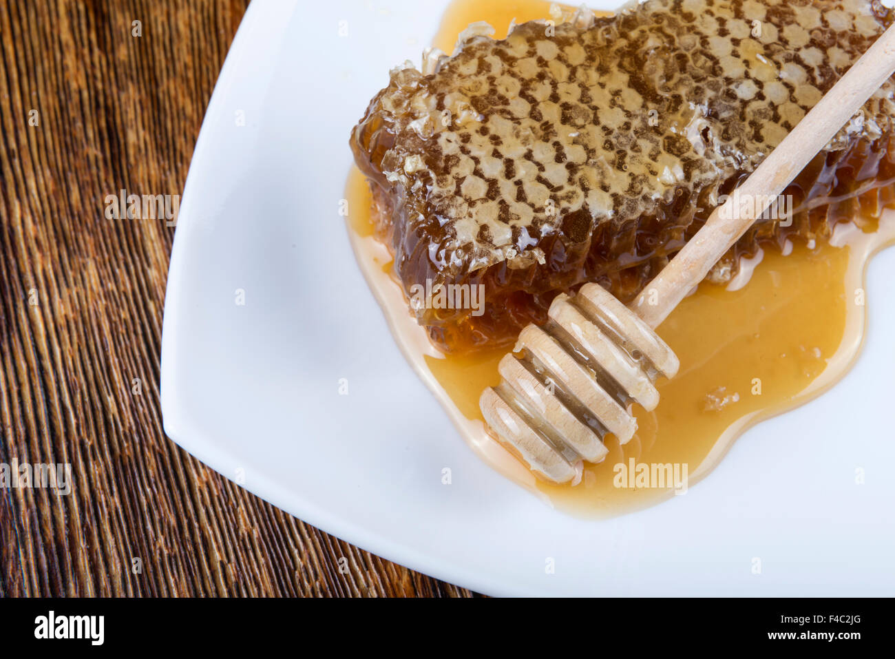 Miel et bâton à miel sur fond de bois Banque D'Images