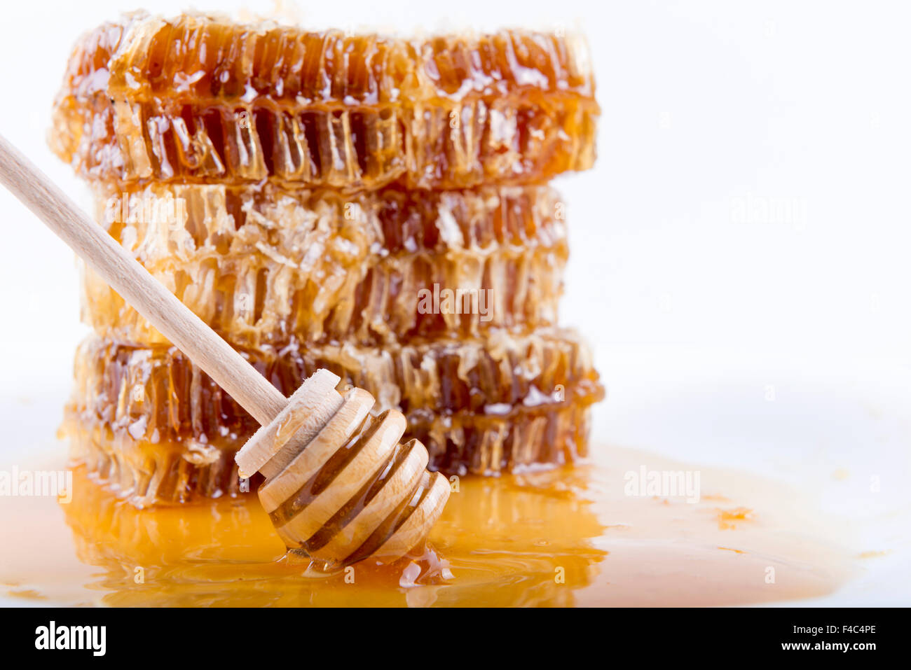 Avec du miel d'abeilles et de miel stick sur fond blanc Banque D'Images