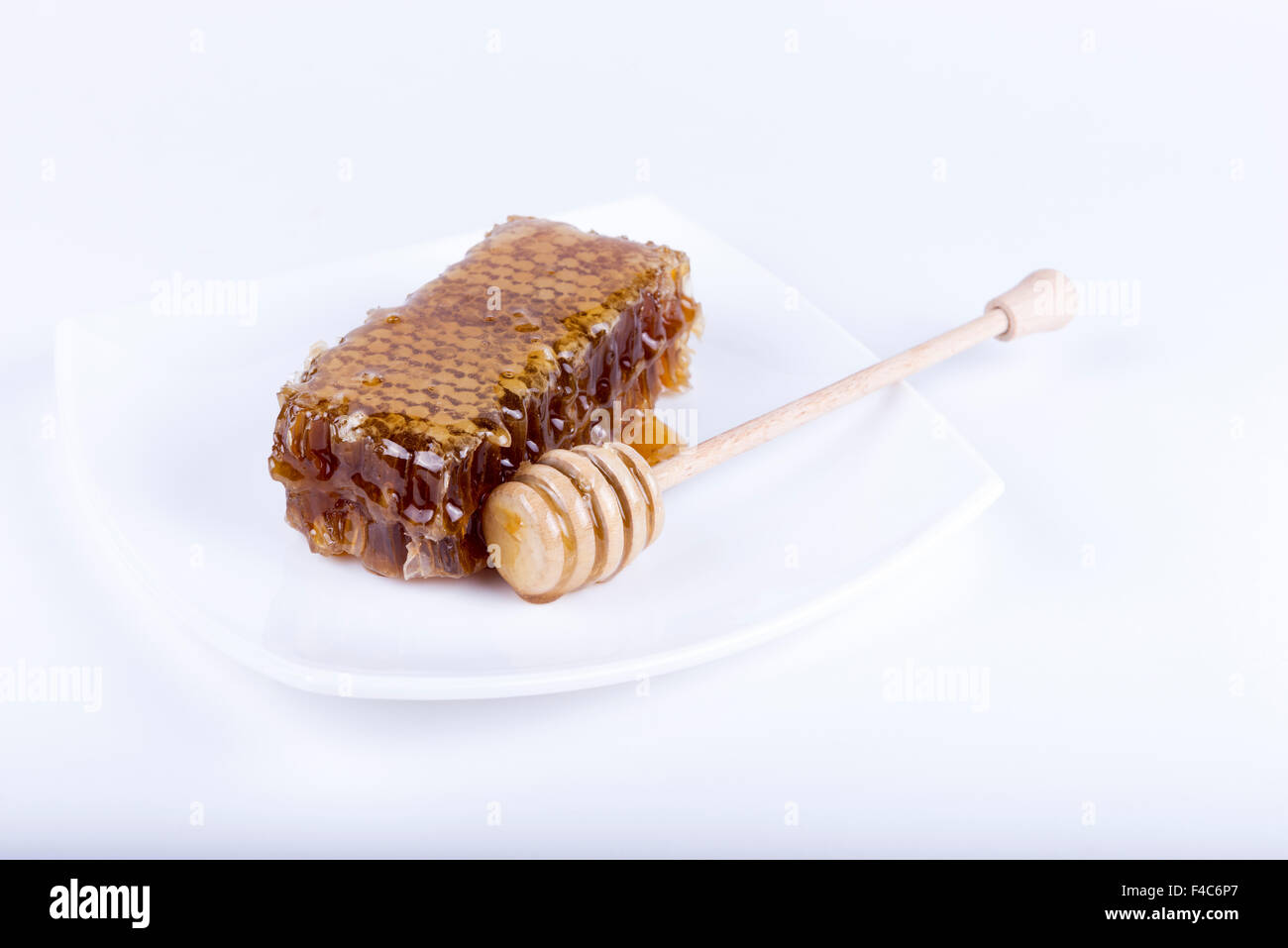 Avec du miel d'abeilles et de miel stick sur fond blanc Banque D'Images