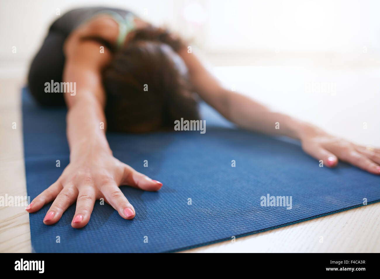 Portrait de l'avant, effectuer une pose de yoga sur tapis d'exercice. Femme Fitness yoga sport balasana à effectuer, l'accent sur les mains Banque D'Images