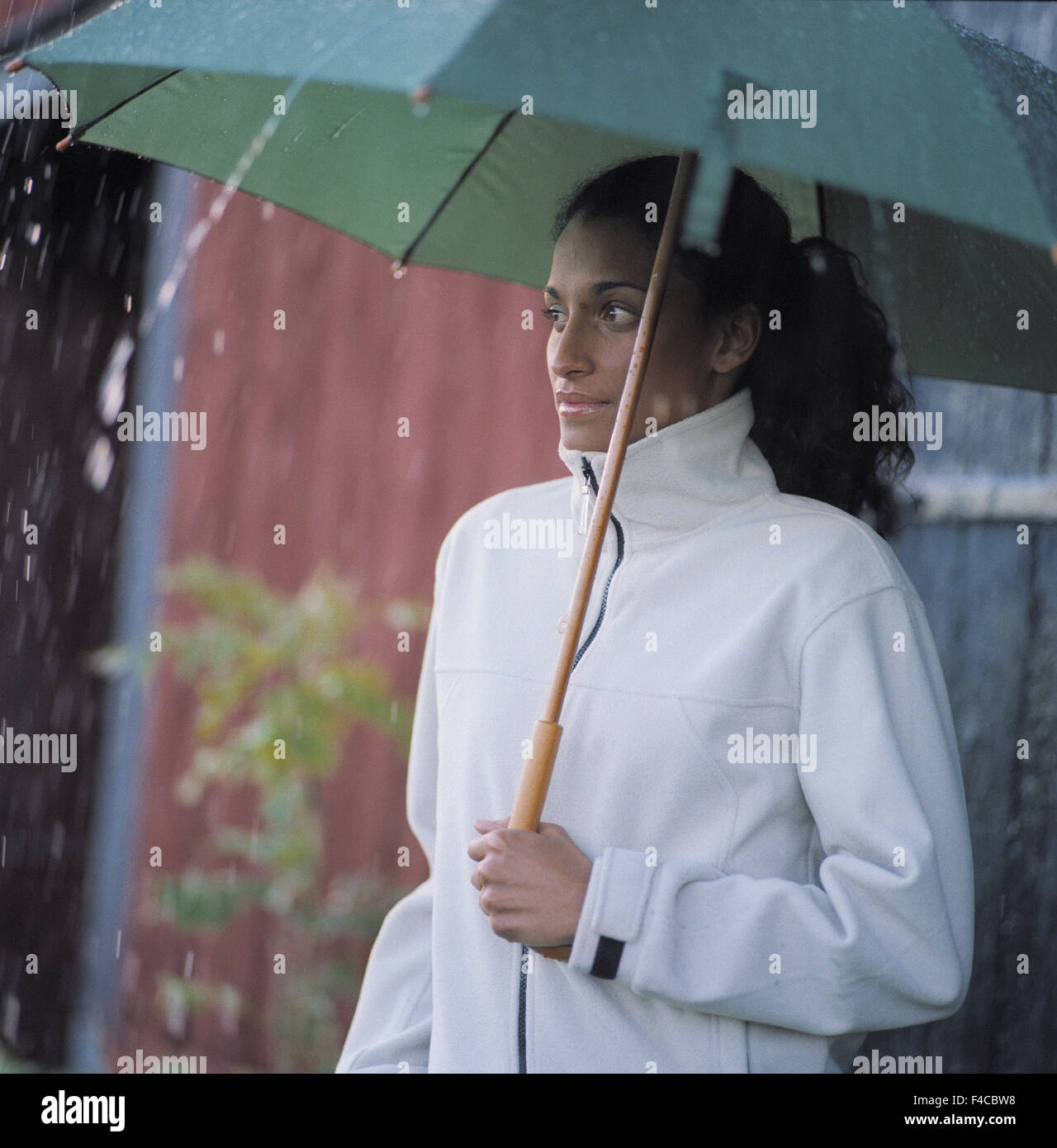 Une femme avec un parapluie dans la pluie Banque D'Images