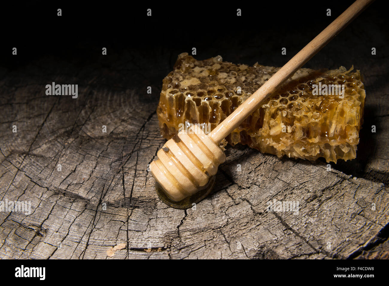 Abeilles et bâton à miel sur fond de bois Banque D'Images