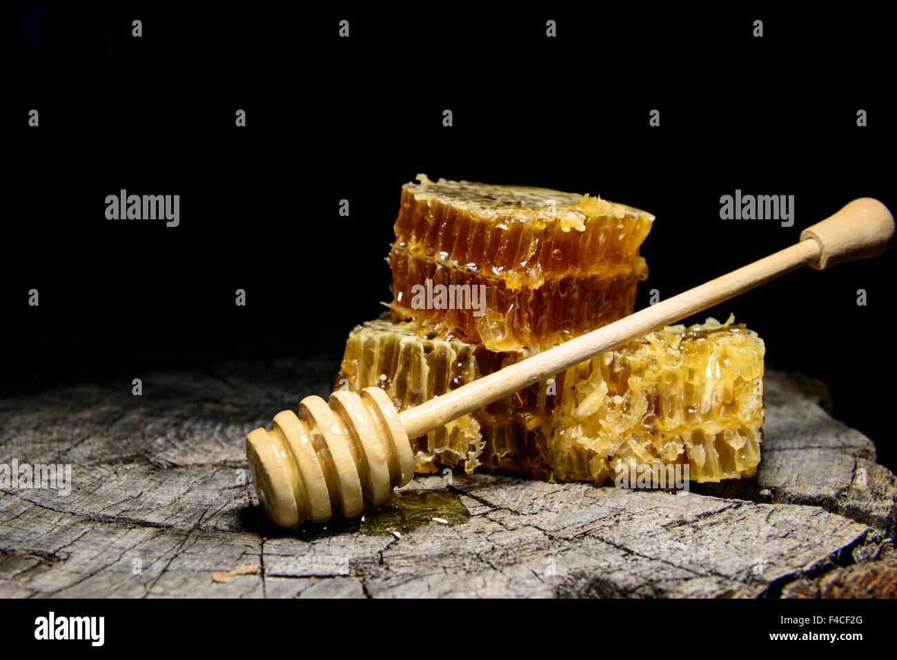 Abeilles et bâton à miel sur fond de bois Banque D'Images