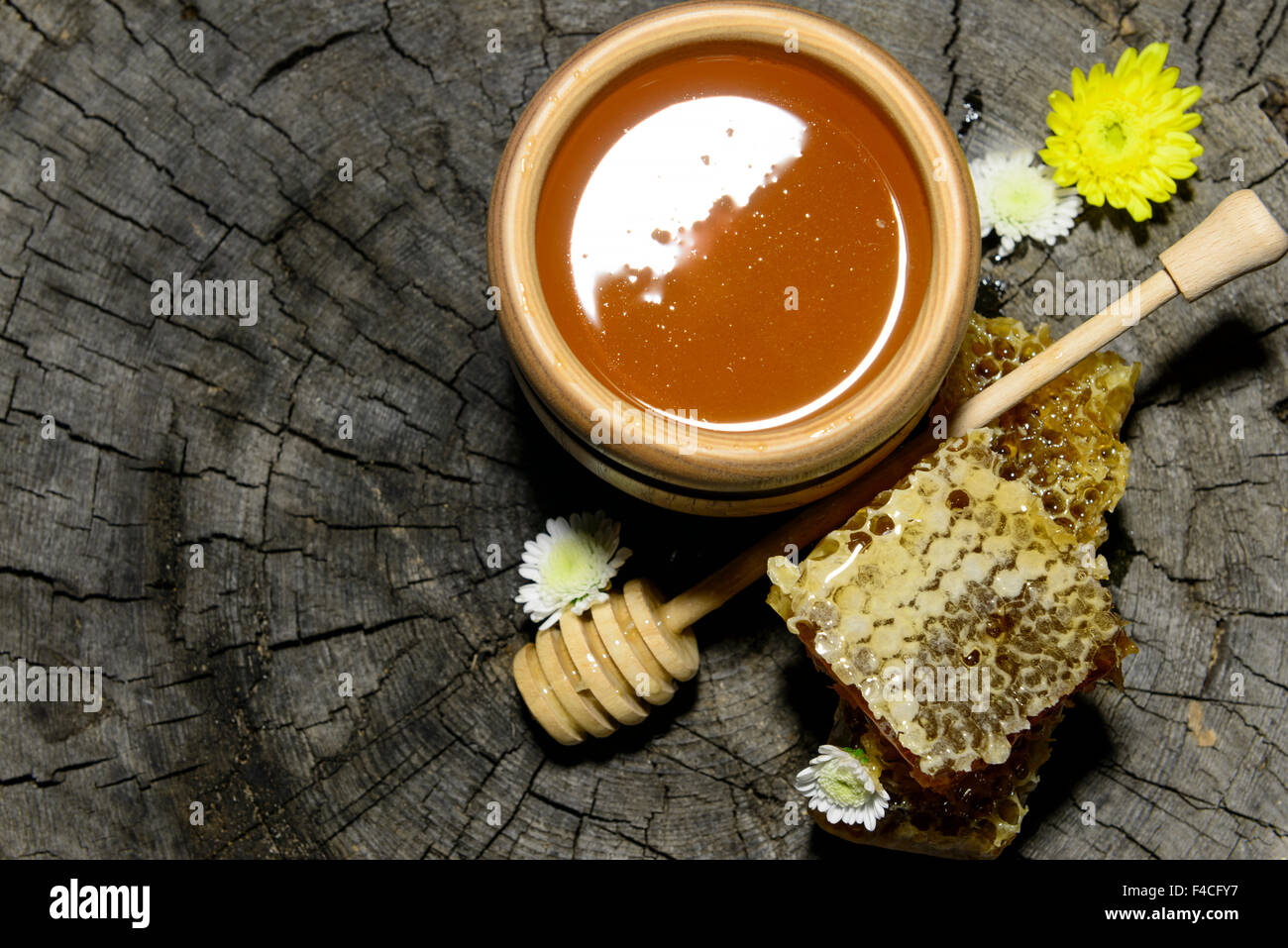 Abeilles et bâton à miel sur fond de bois Banque D'Images