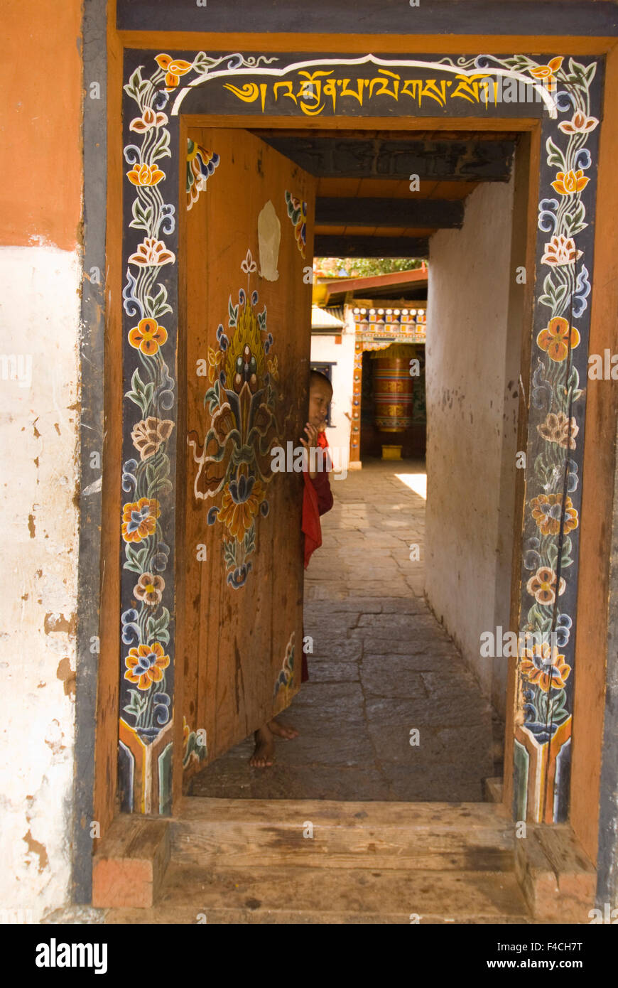 Moine dans la porte du temple de la Divine Madman (Chimi Lhakhang) près de Punakha, Bhoutan. Banque D'Images