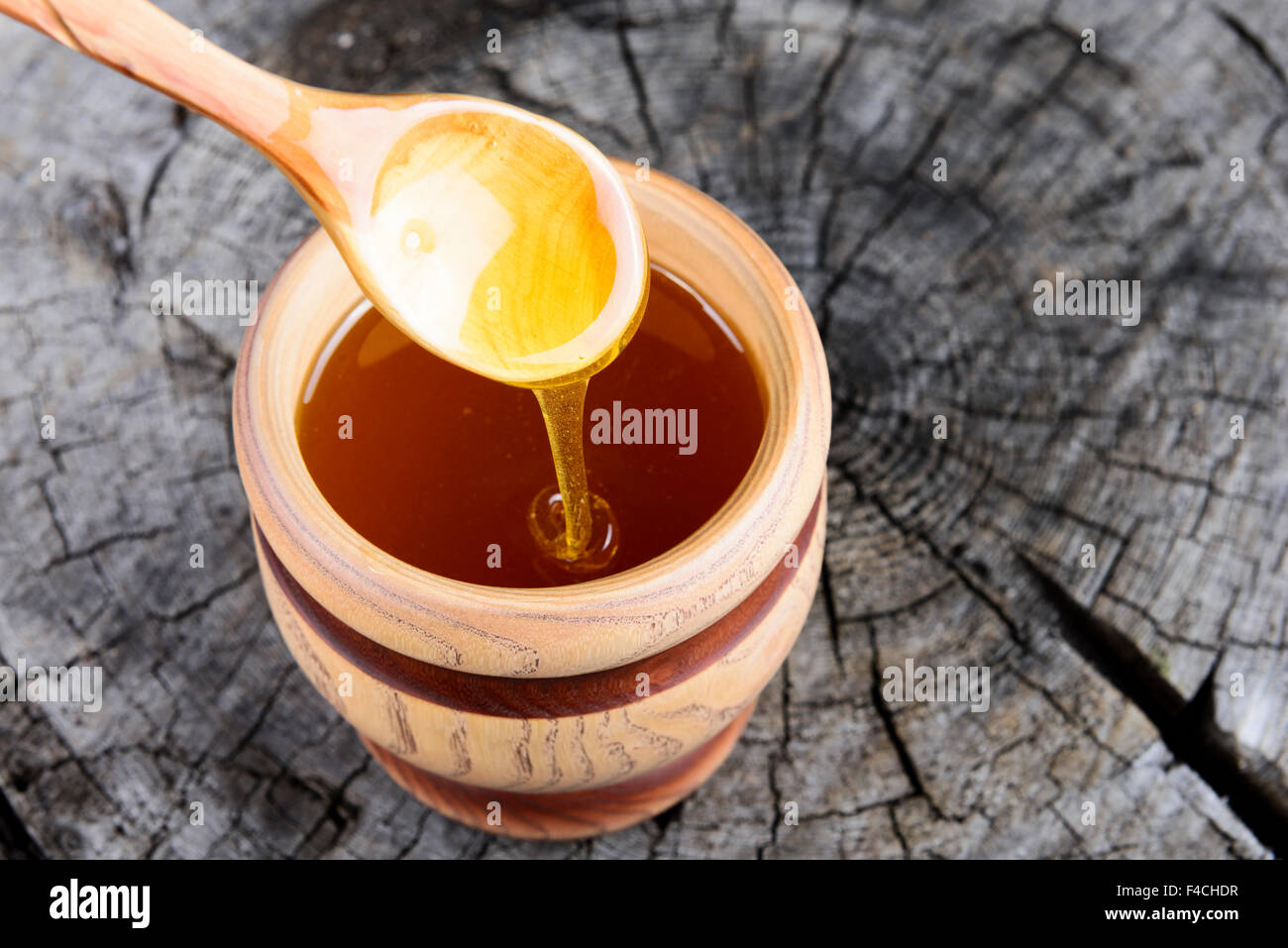 Pot de miel et une cuillère de miel sur un fond de bois Banque D'Images