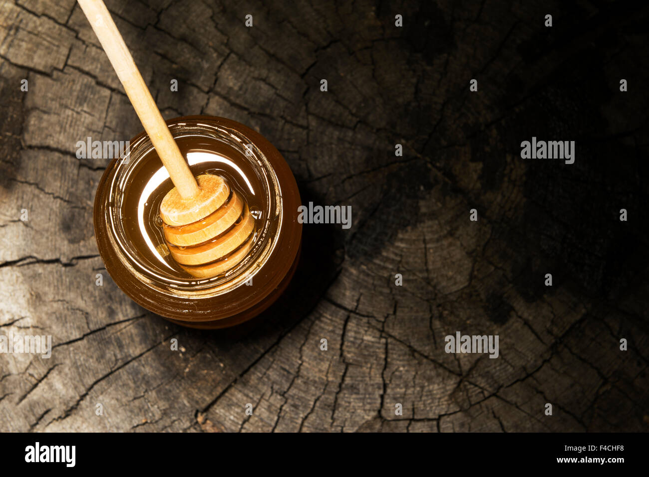 Pot de miel et bâton à miel sur un fond de bois Banque D'Images