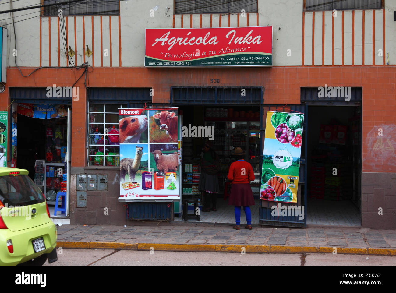 Les femmes quechua à l'extérieur d'un magasin qui vend des engrais et des produits agricoles, Cusco, Pérou Banque D'Images