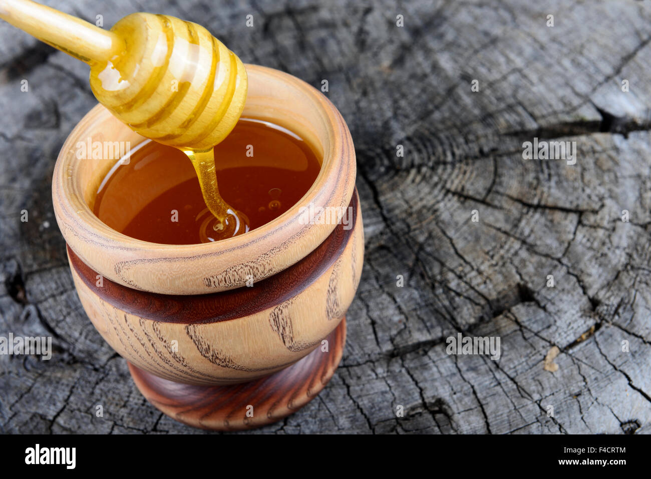 Pot de miel et bâton à miel sur un fond de bois Banque D'Images