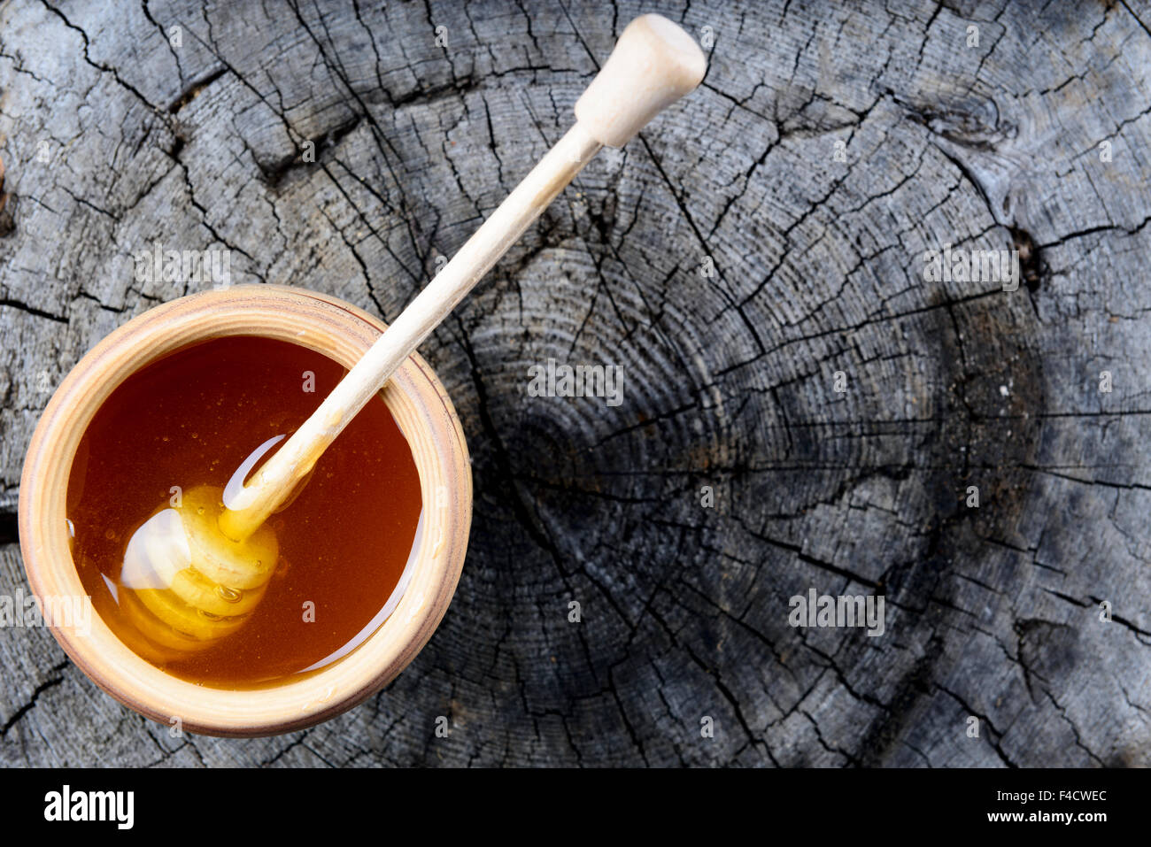 Pot de miel et bâton à miel sur un fond de bois Banque D'Images