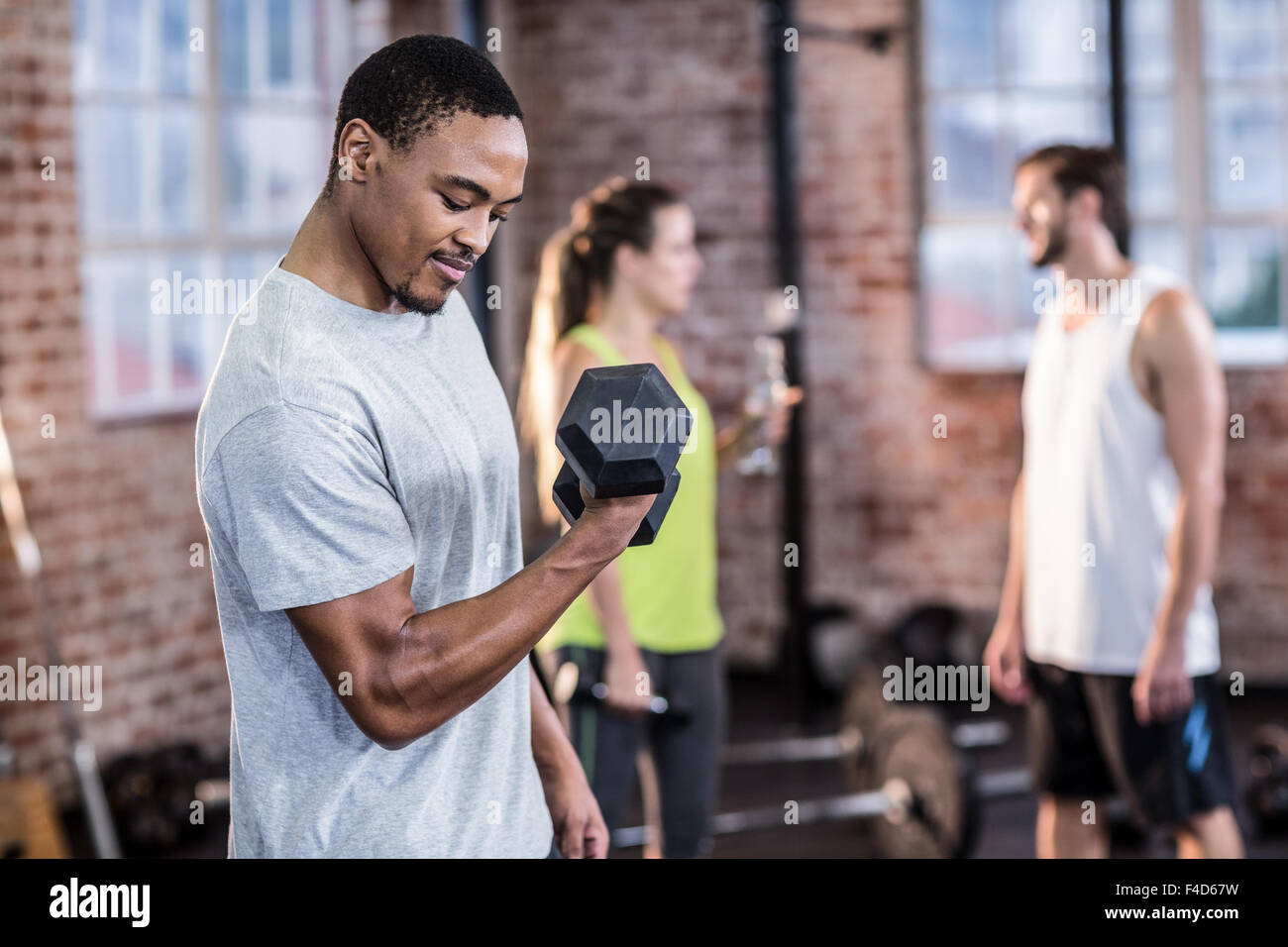 Muscular man exercising with dumbbell Banque D'Images