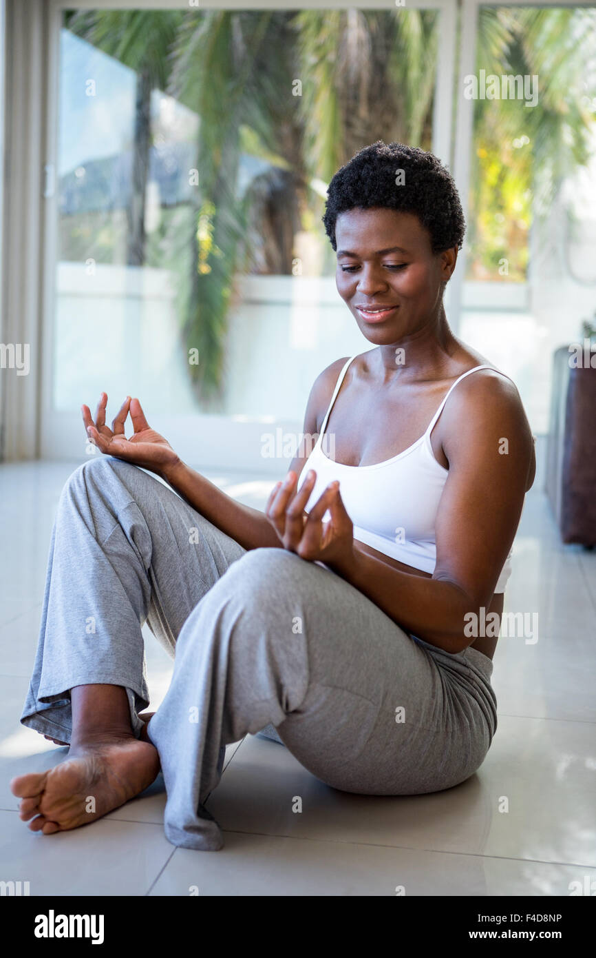 Cheerful pregnant woman sitting in lotus pose Banque D'Images