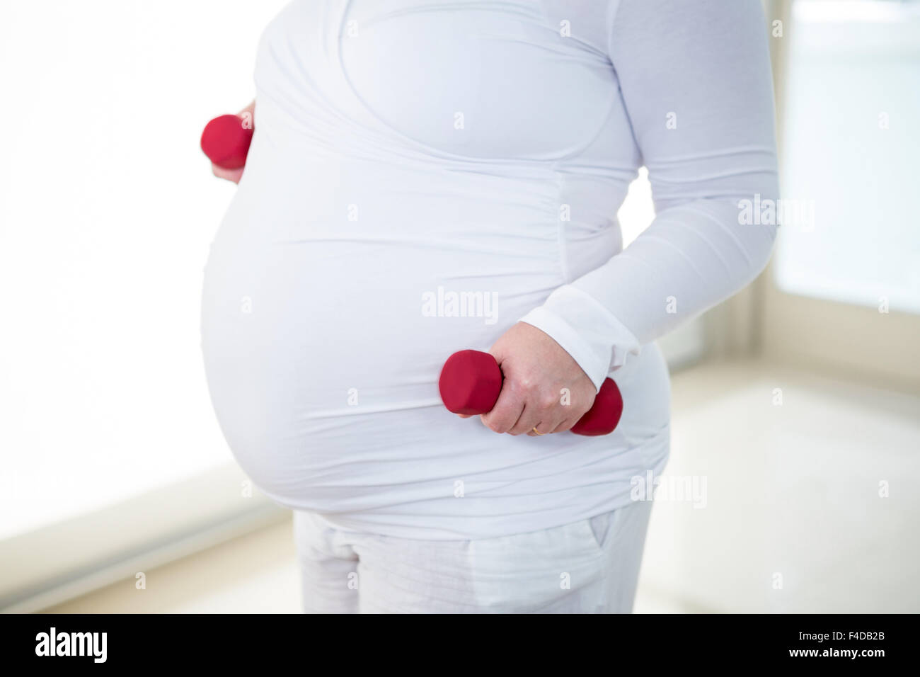 Mid section of pregnant woman doing exercise Banque D'Images