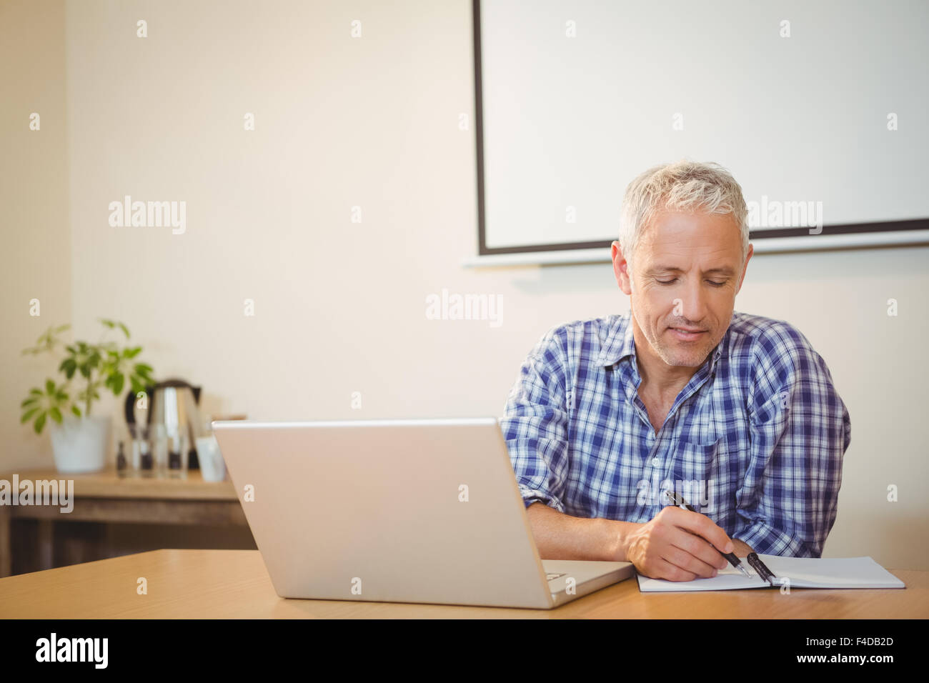 Homme d'écriture créative dans l'ordinateur portable Banque D'Images