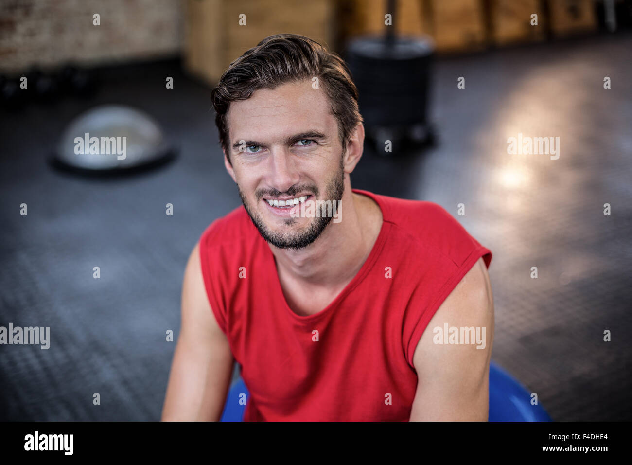 Formateur souriant assis sur ballon Banque D'Images