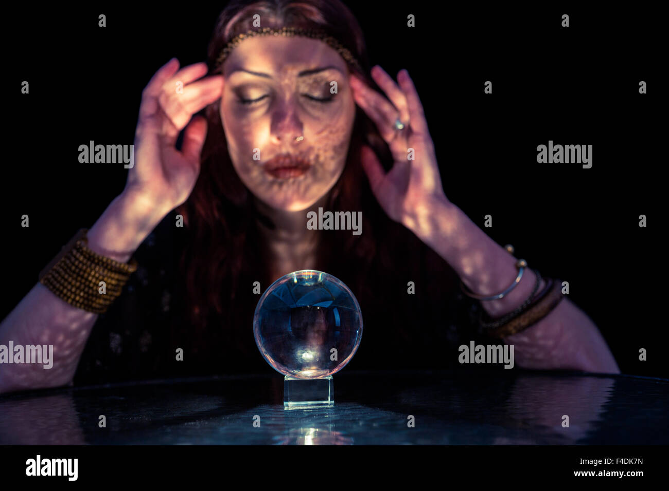 Fortune Teller femme à l'aide de crystal ball avec les yeux fermé Banque D'Images