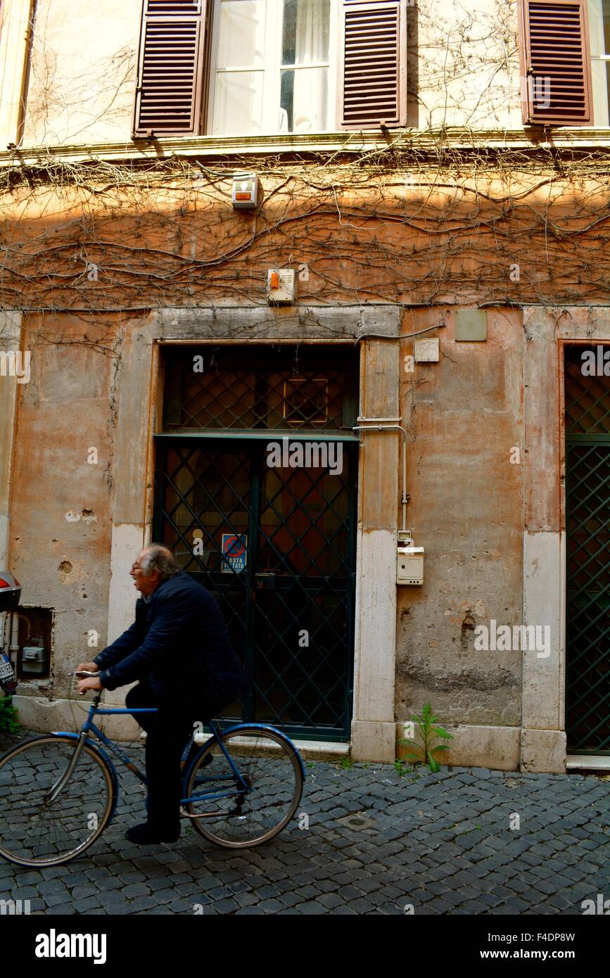 Homme de rouler à vélo dans une rue pavée dans le Trastevere, Rome, Italie Banque D'Images