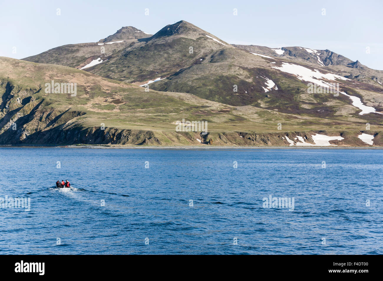 La Russie, Kamchatka, Verkhoturov Island, les gens à explorer la mer avec montagnes au-dessus. Banque D'Images