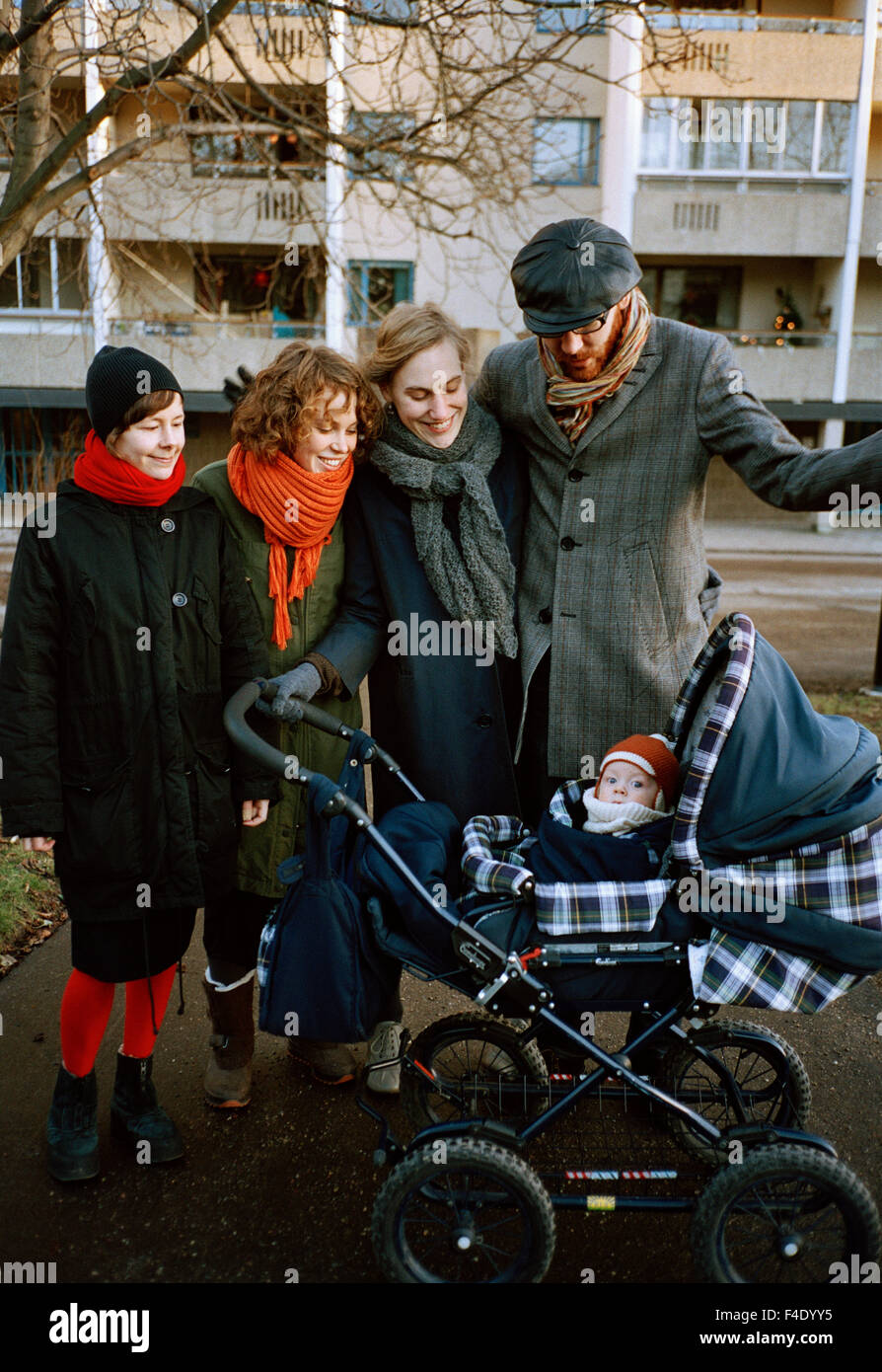 Quatre grandes personnes réunis autour d'une perambulator, Stockholm, Suède. Banque D'Images