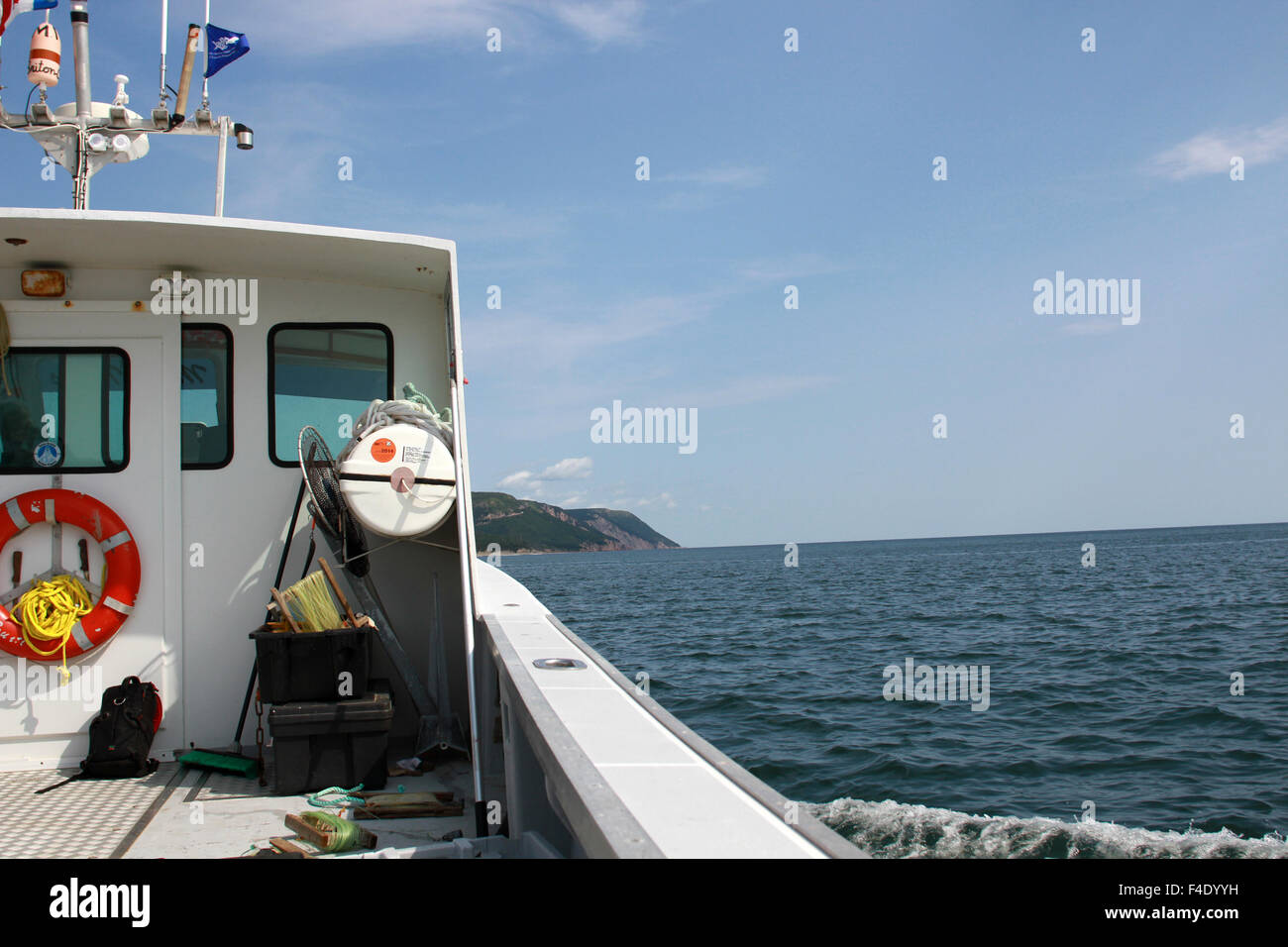 Un bateau de pêche remonte la rive nord du Cap-Breton, en Nouvelle-Écosse. Banque D'Images