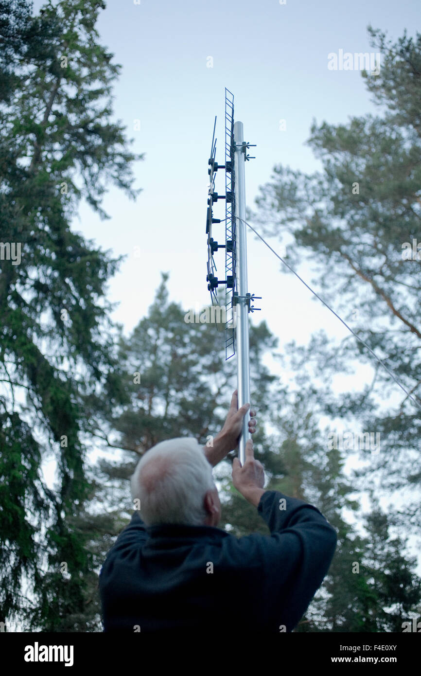 Un vieil homme tenant une antenne de télévision numérique, la Suède. Banque D'Images