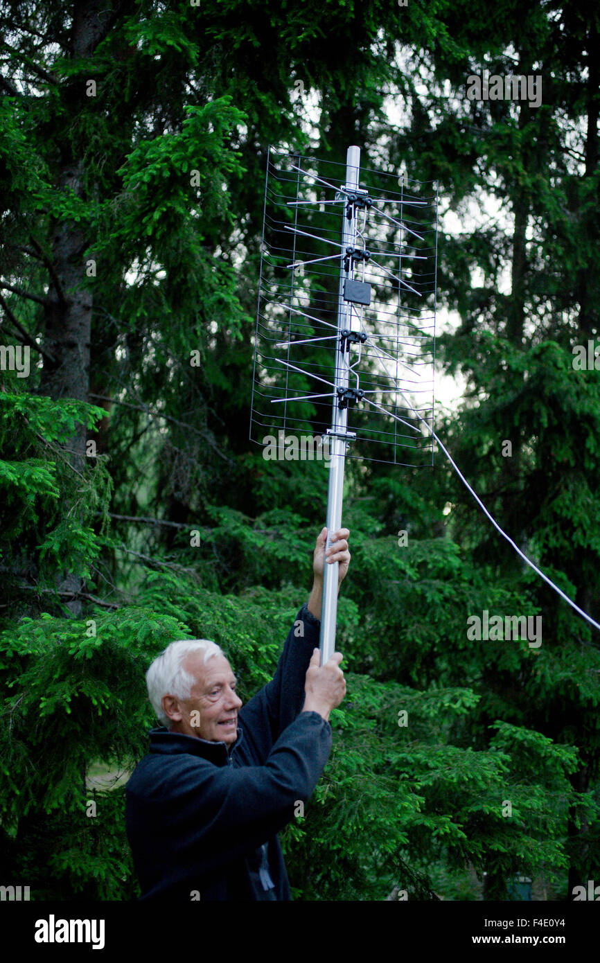 Un vieil homme tenant une antenne de télévision numérique, la Suède. Banque D'Images