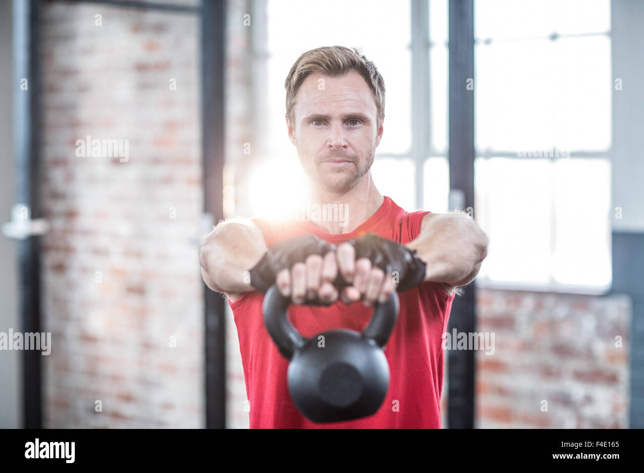 L'accent musculaire man lifting kettlebells Banque D'Images