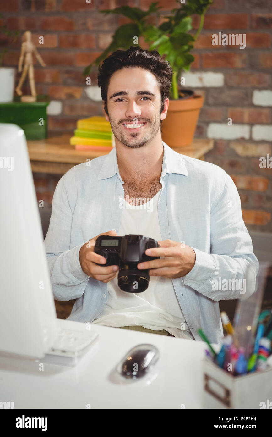 Portrait of smiling editor holding camera Banque D'Images