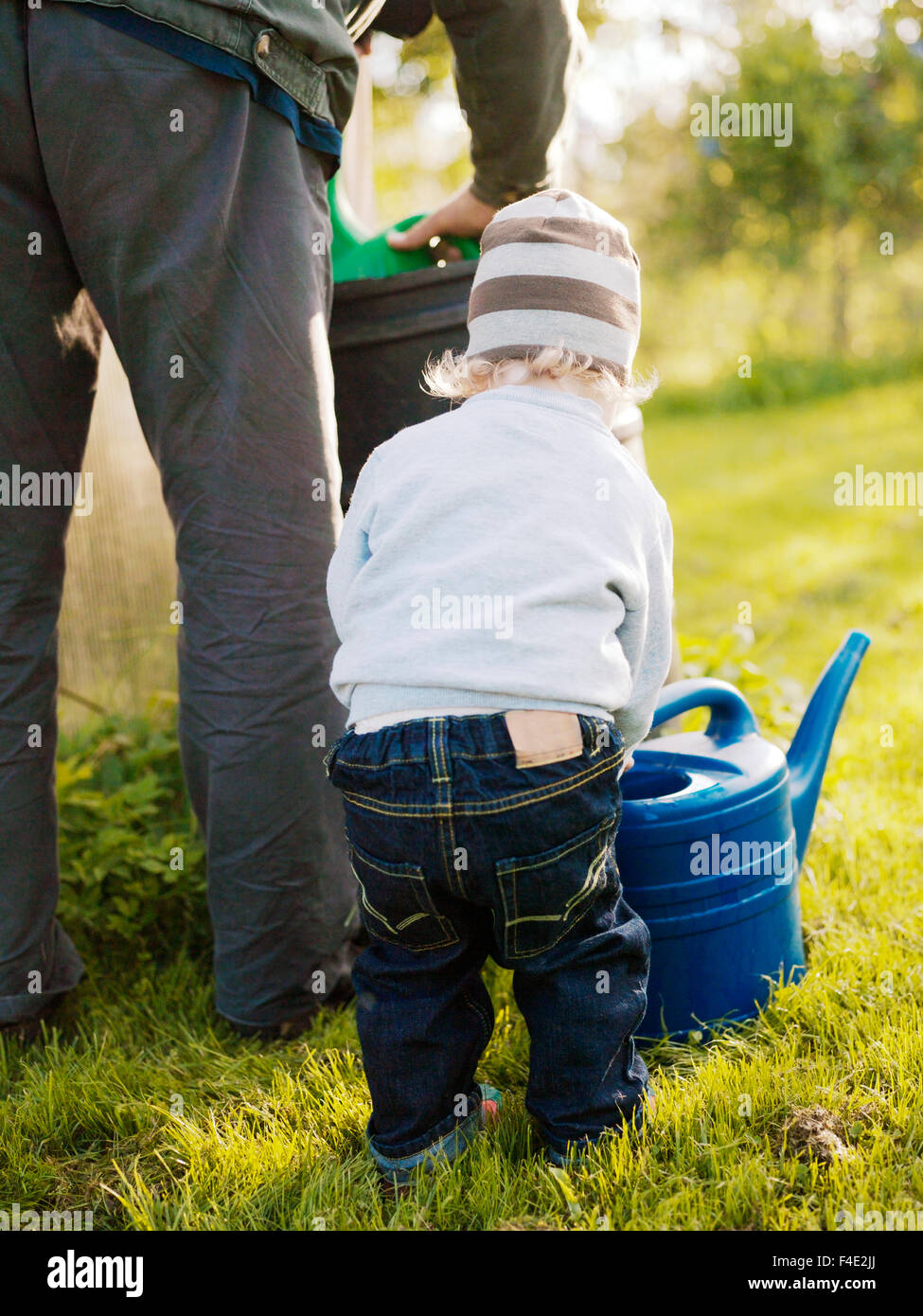 Grand-père et petit-fils à l'aide d'une cruche d'eau, la Suède. Banque D'Images