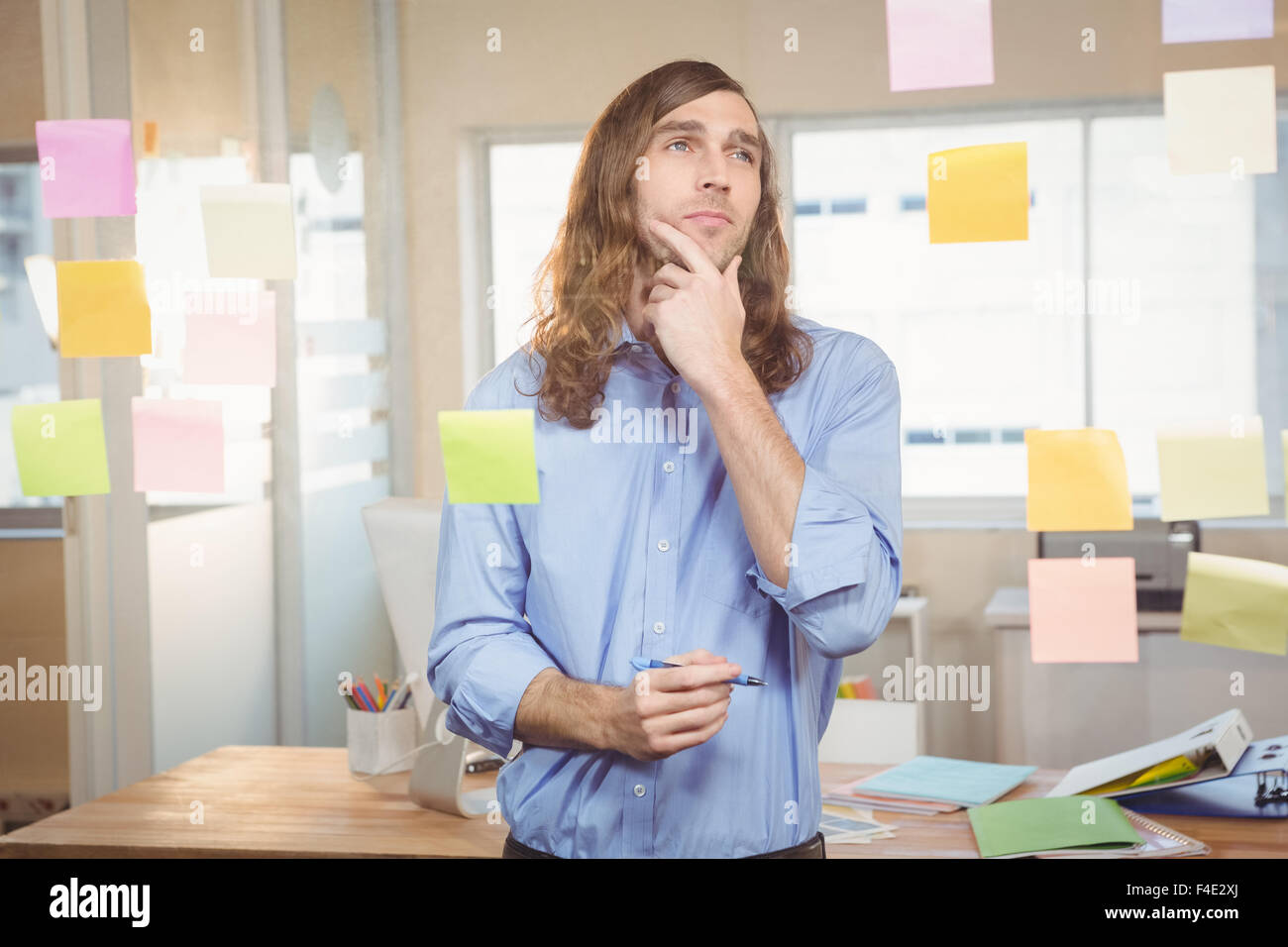 Thoughtful businessman looking at sticky notes Banque D'Images