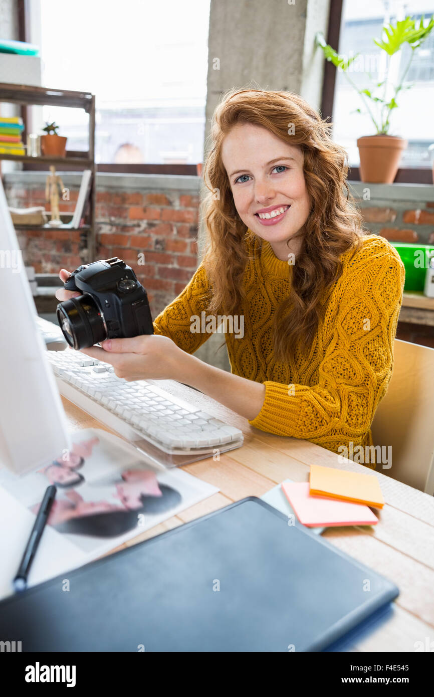 Smiling woman holding camera Banque D'Images