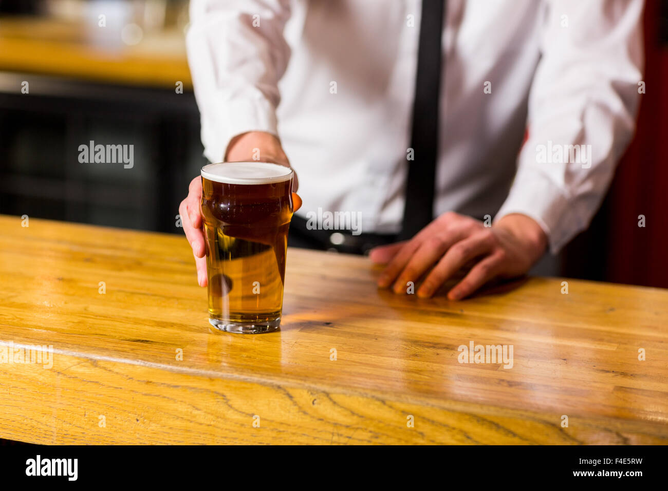 On y sert de la bière barman bien habillé Banque D'Images