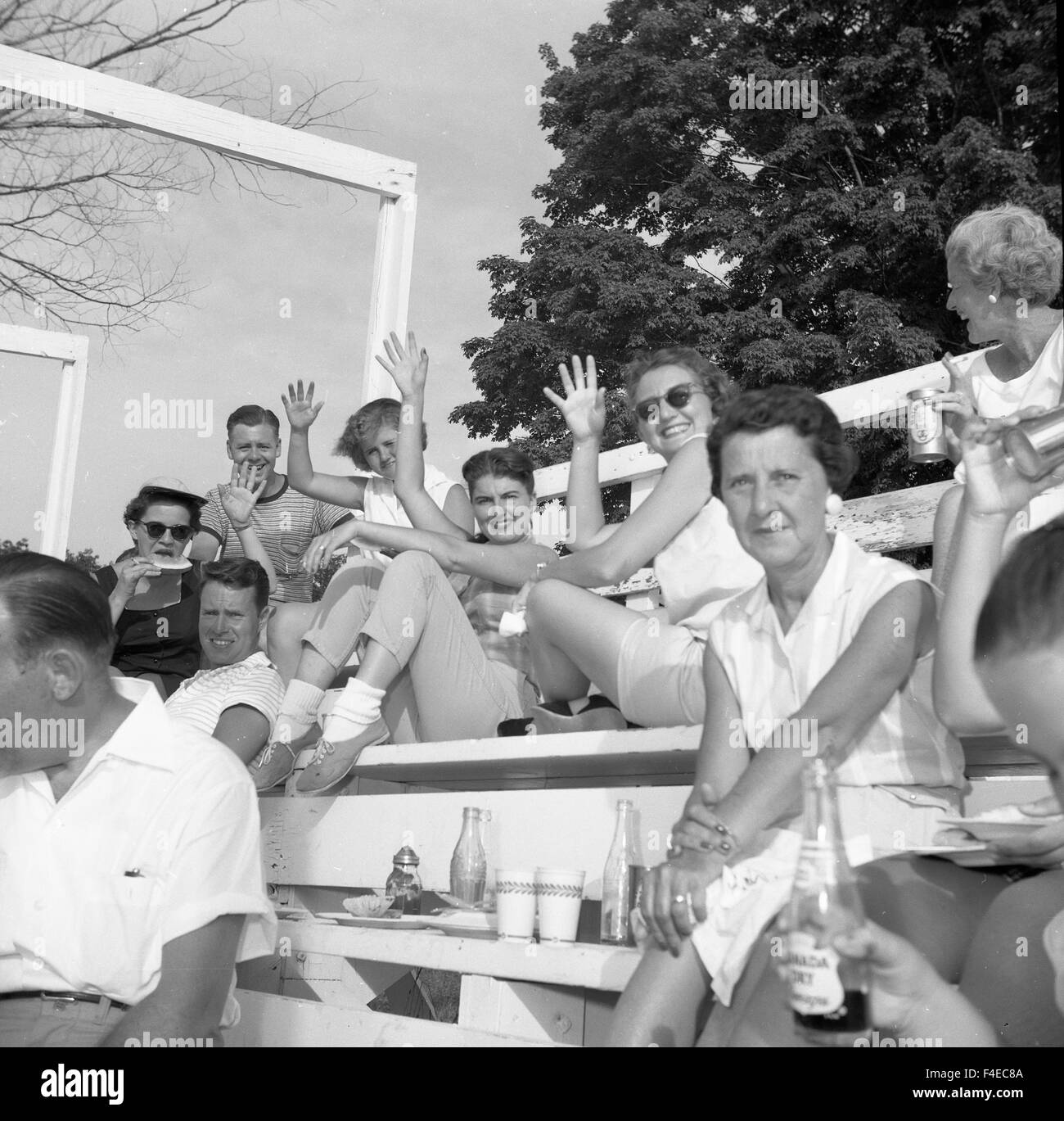 1960 Rassemblement des gens assis sur des béquilles. adolescentes waving Banque D'Images