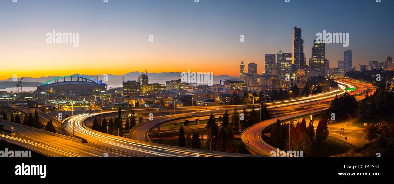 USA, l'État de Washington. Seattle skyline au coucher du soleil près de la 12ème rue (Jose Rizal) pont. En vue sont Le Seahawk Stadium (siècle), Smith Tower, Columbia, le centre ville, J-5 et J-90 interchange. Tailles disponibles (grand format). Banque D'Images