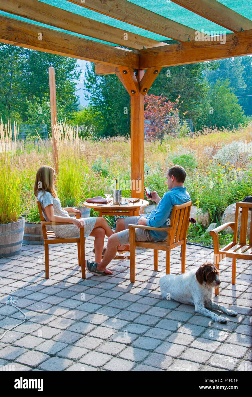 USA, Washington, Winthrop. L'homme et la femme profiter du patio d'une cave à vin de l'Okanagan la boucle avec chien. Banque D'Images