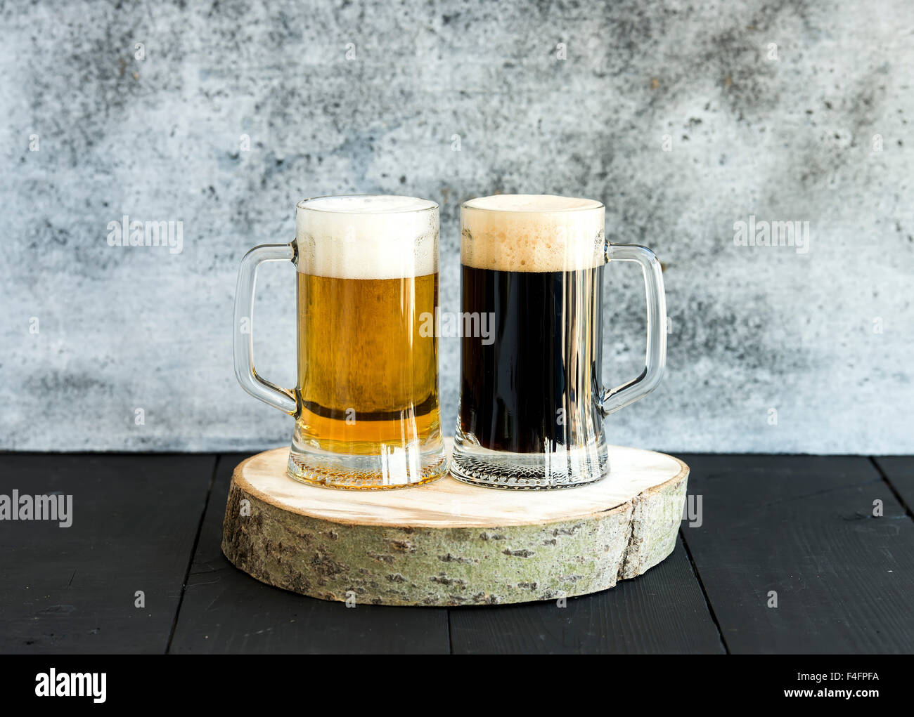 La lumière et l'obscurité de la bière dans des tasses sur planche de bois, toile grunge Banque D'Images