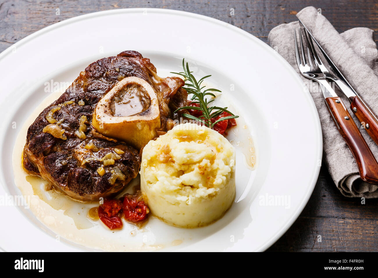 Les plats osso buco de veau avec les tomates et la purée de pomme de