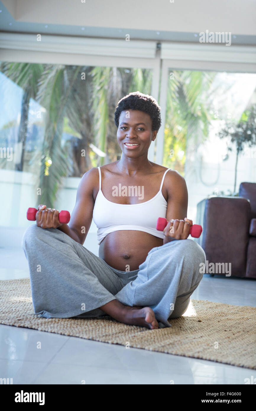 Portrait de femme heureuse avec haltères assis Banque D'Images
