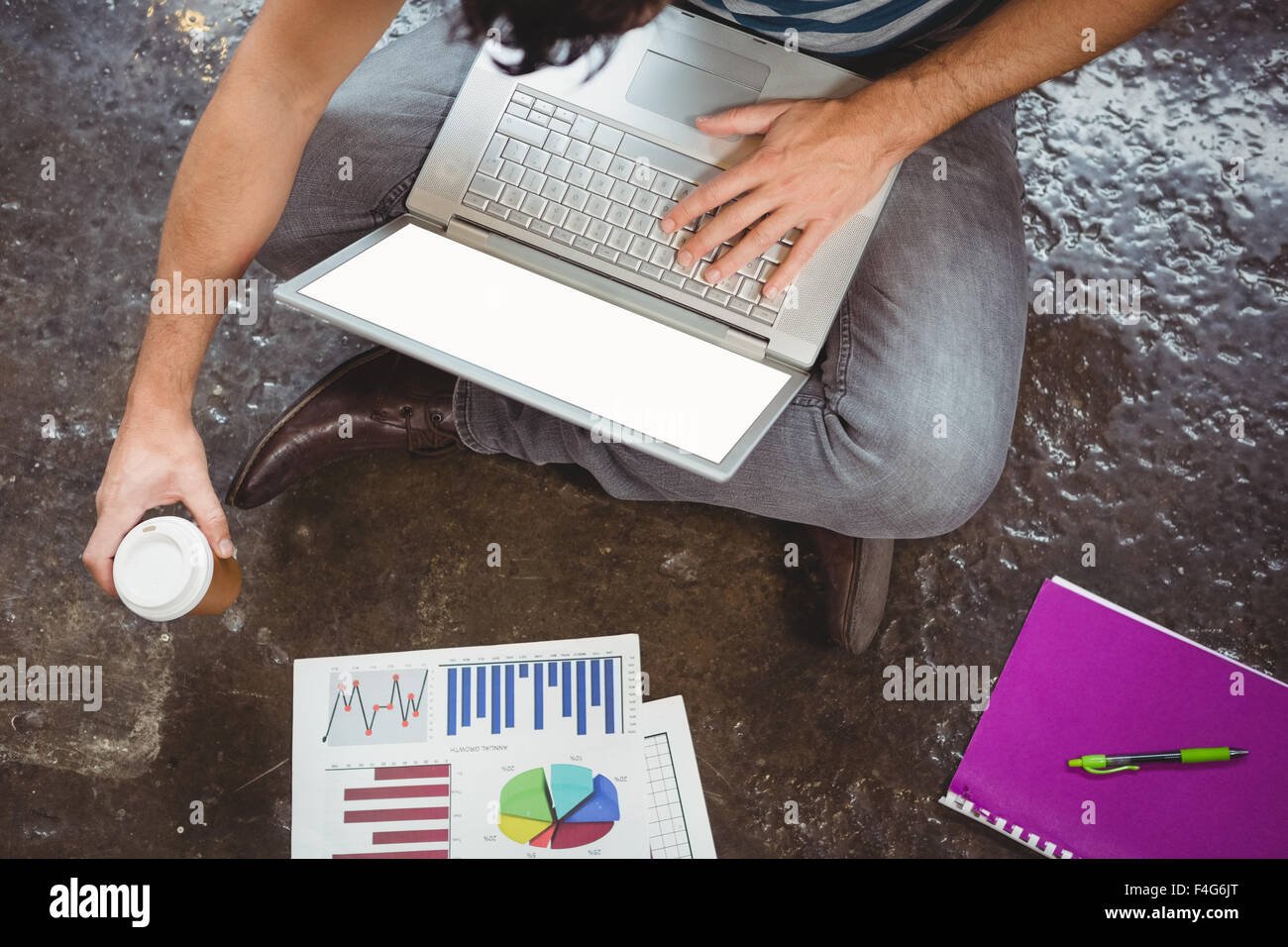 La section basse de businessman using laptop tout en maintenant tasse Banque D'Images